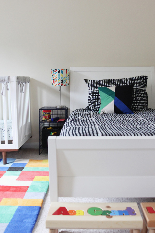 A twin bed and a crib in a boys' shared bedroom.