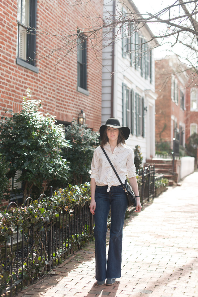 A classic black and white polka dot shirt tied at the waist with flare jeans
