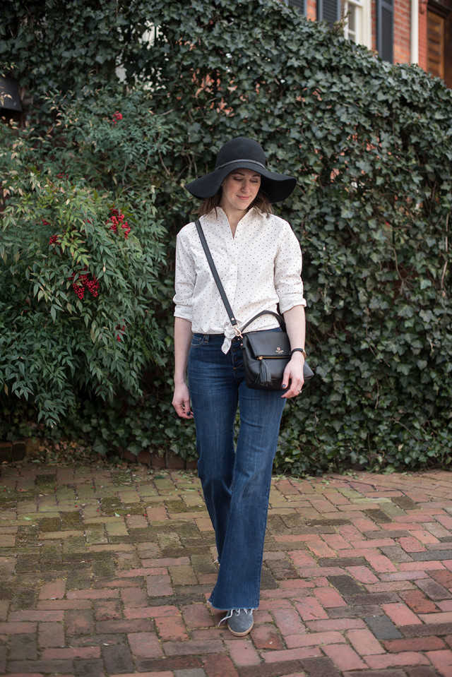 A simple black and white polka dot shirt with flare jeans and a floppy black hat