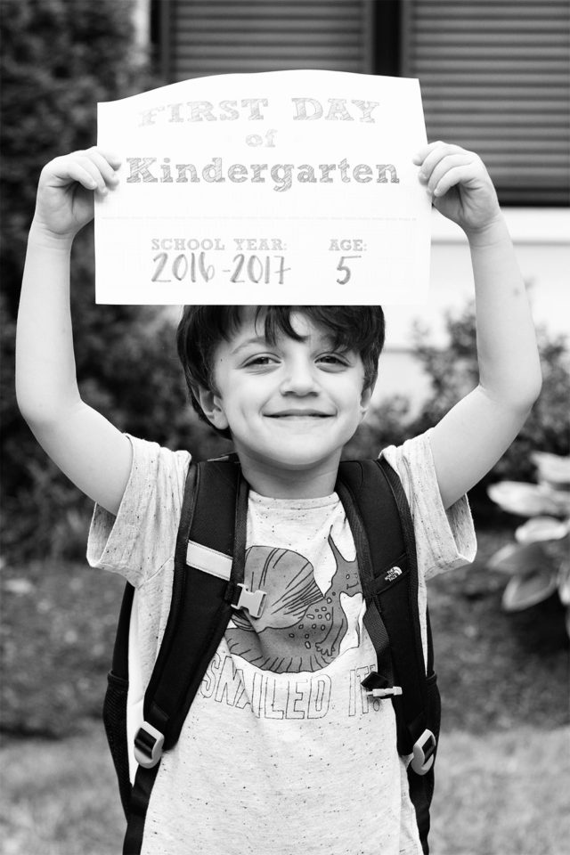 Holding a First Day of Kindergarten sign!